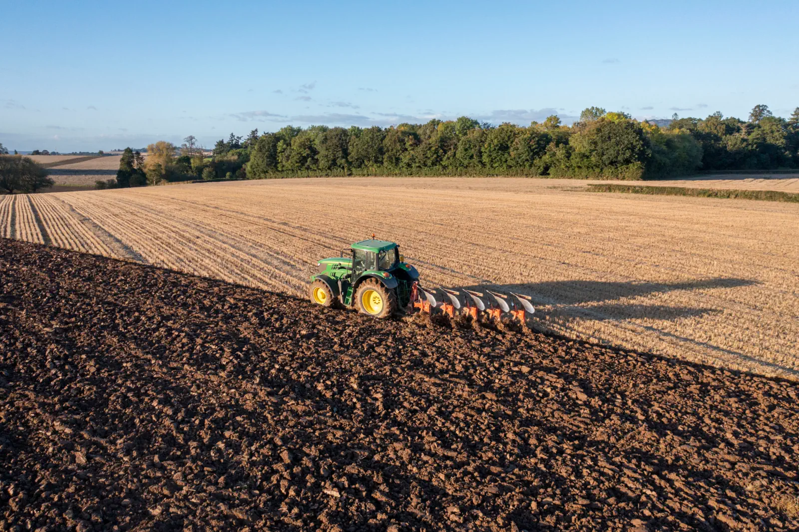 A tractor ploughing a field near Cressage, England, in low sun