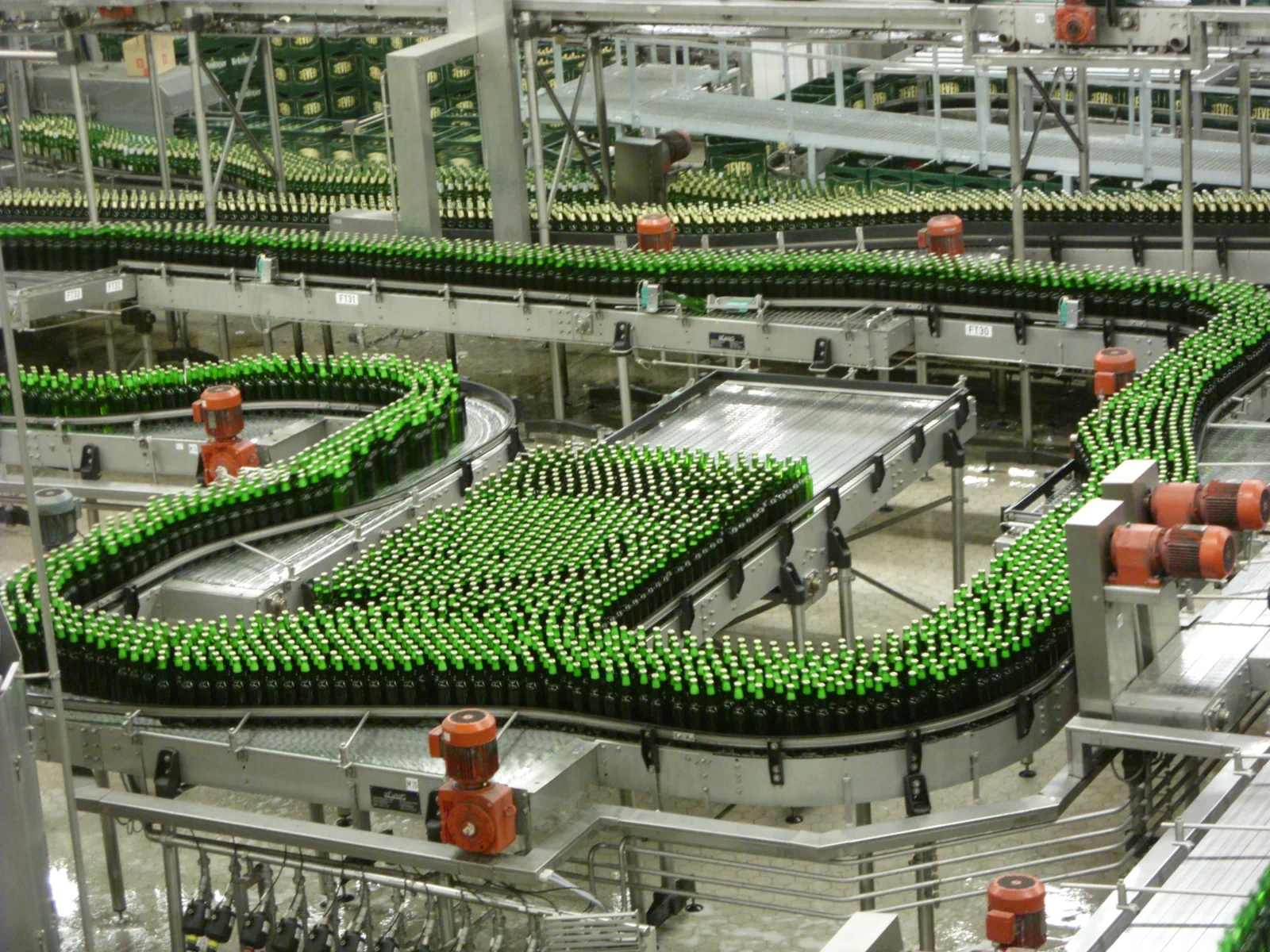 Green beer bottles moving along conveyor lines in the filling hall of the Krostitzer brewery, Germany